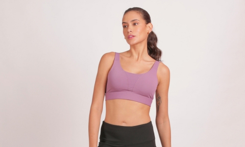 Woman wearing a medium-impact padded sports bra, showcasing comfort and style while preparing for an energetic workout.