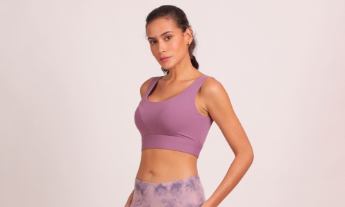 A model showcases a stylish purple sports bra and matching leggings, exuding confidence and athleticism.