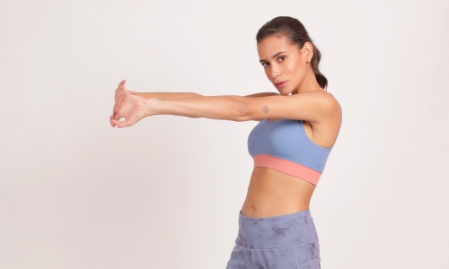 A woman in a blue sports bra with removable padding, showcasing comfort and style during her workout.